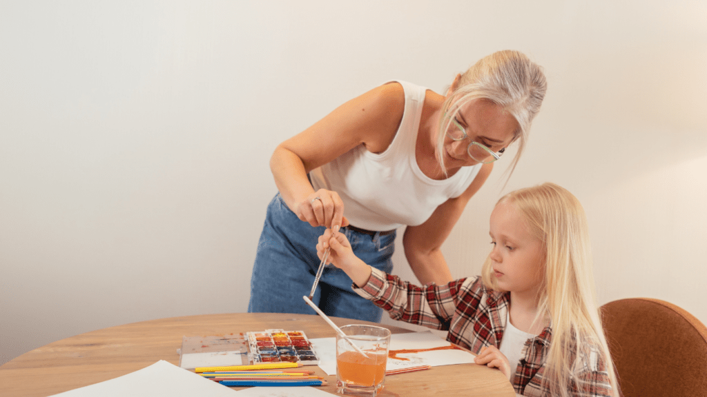 a woman and a child doing a painting