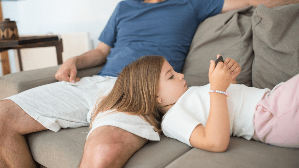 A person laying on a couch with a cell phone