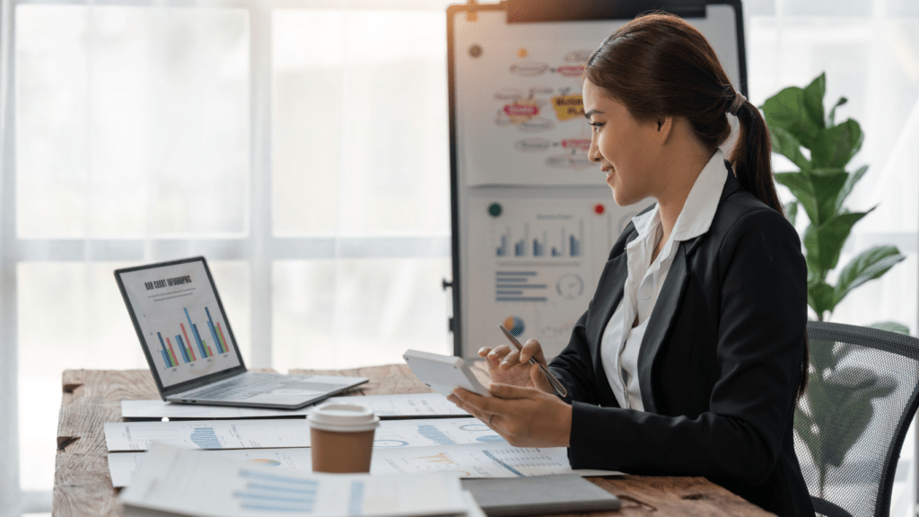 A woman in an office with a laptop and a cup of coffee