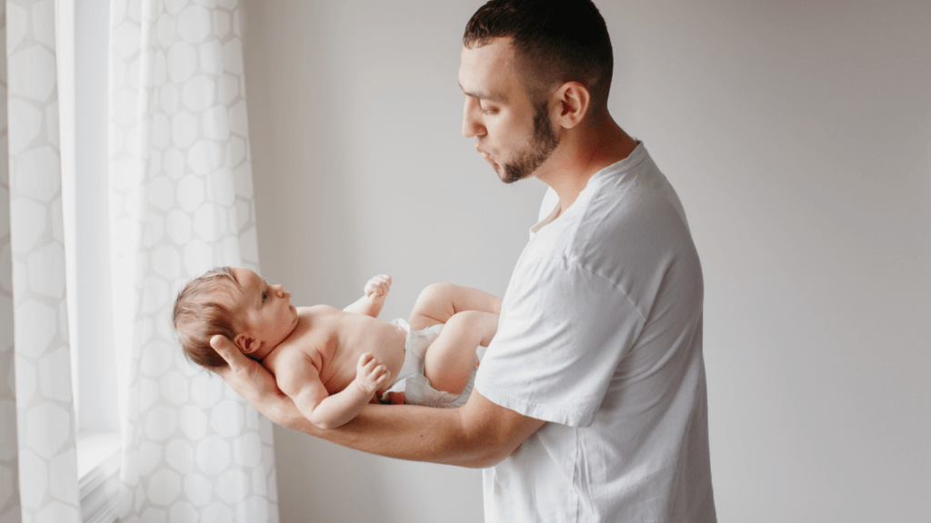 a person holding a baby while standing