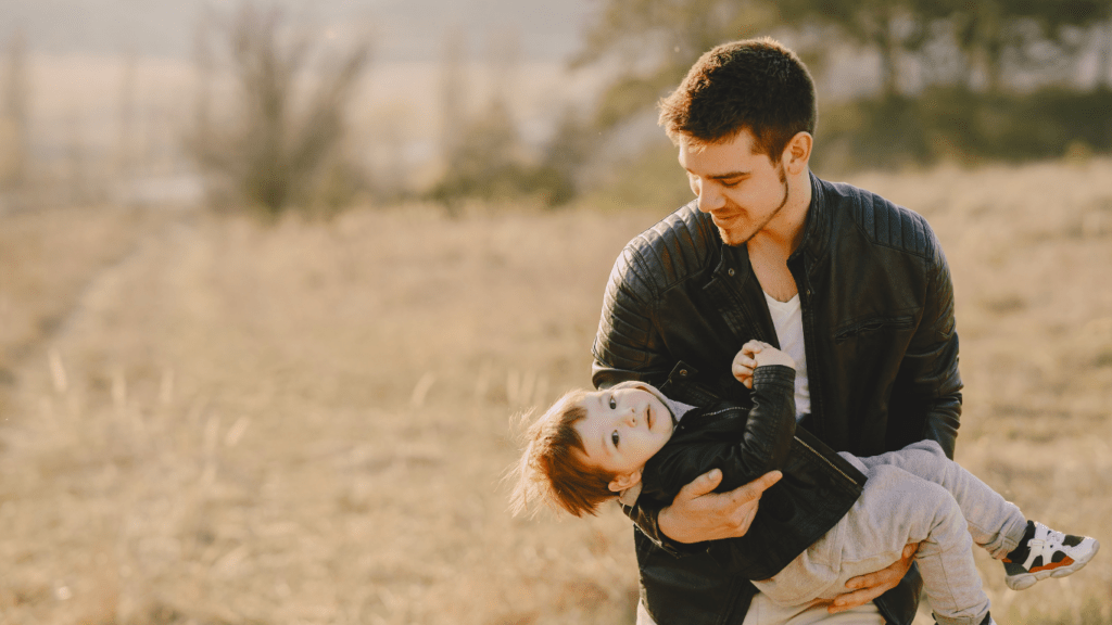 a person holding a child in the middle of a field