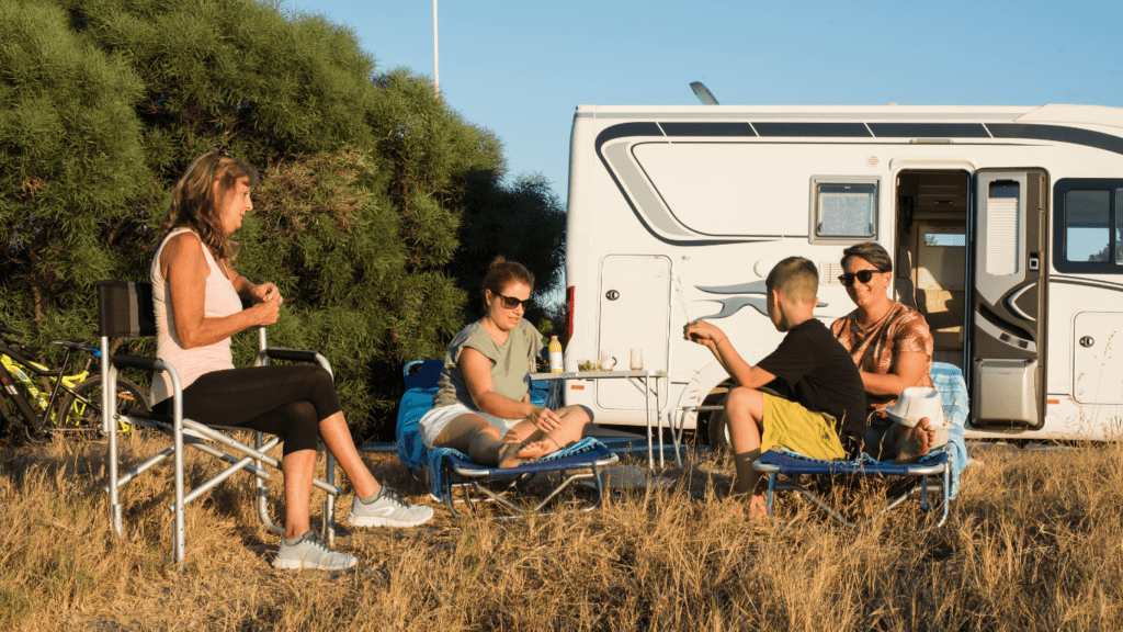 a group of people sitting on chairs in front of an rv