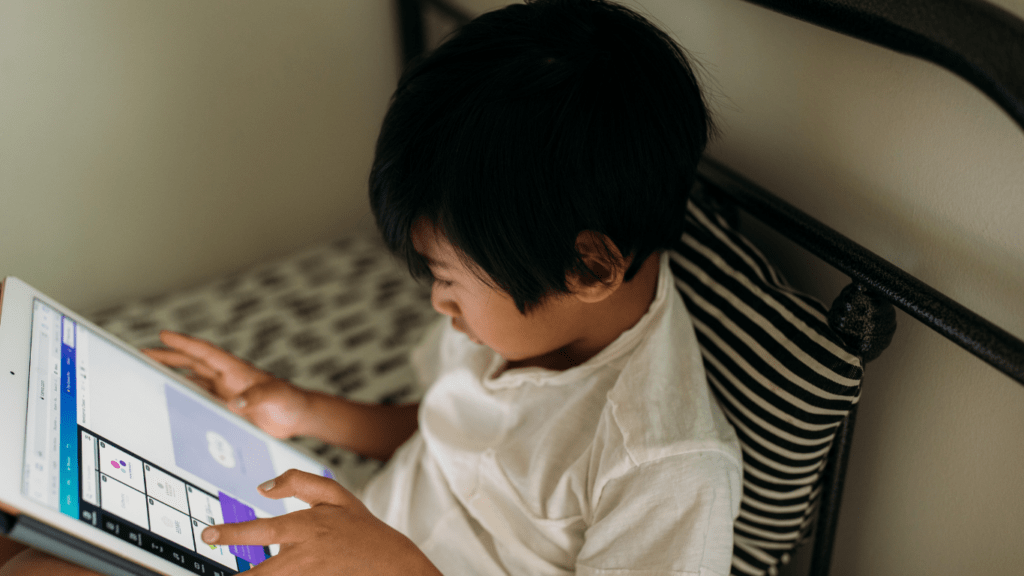 a person sitting on a bed using an ipad