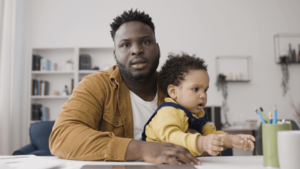 A man holding a baby while sitting at a table