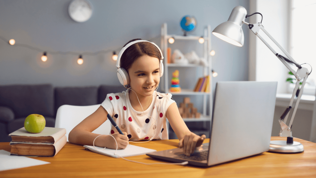 a child sitting at the table using a laptop