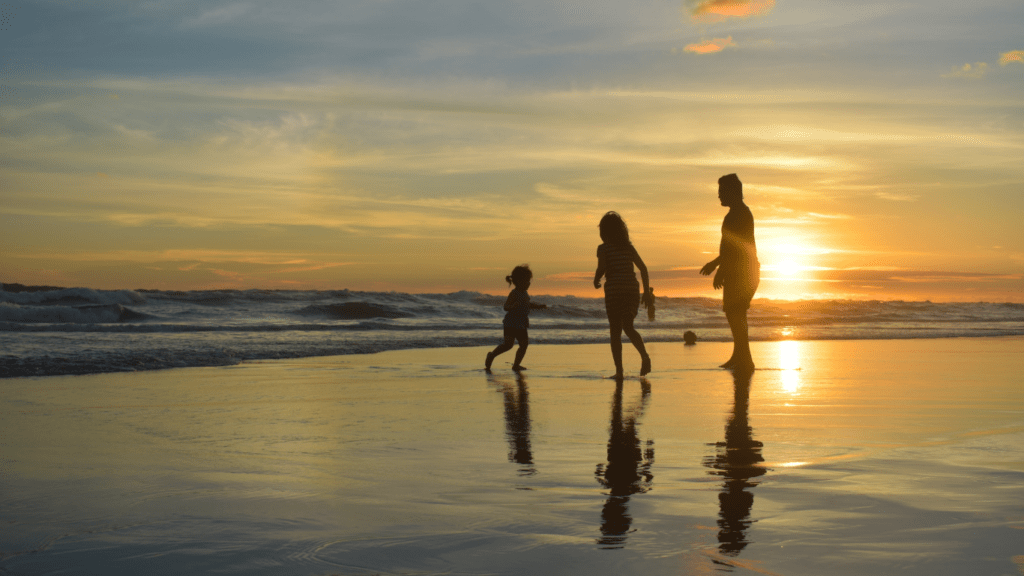 a family running through the water at the beach