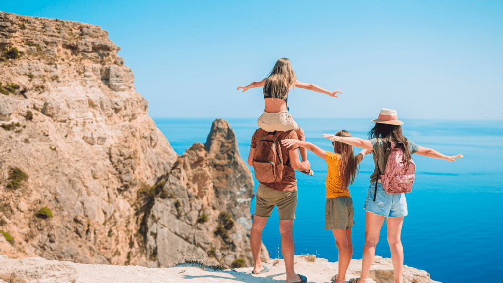 a family standing in shallow water on the beach