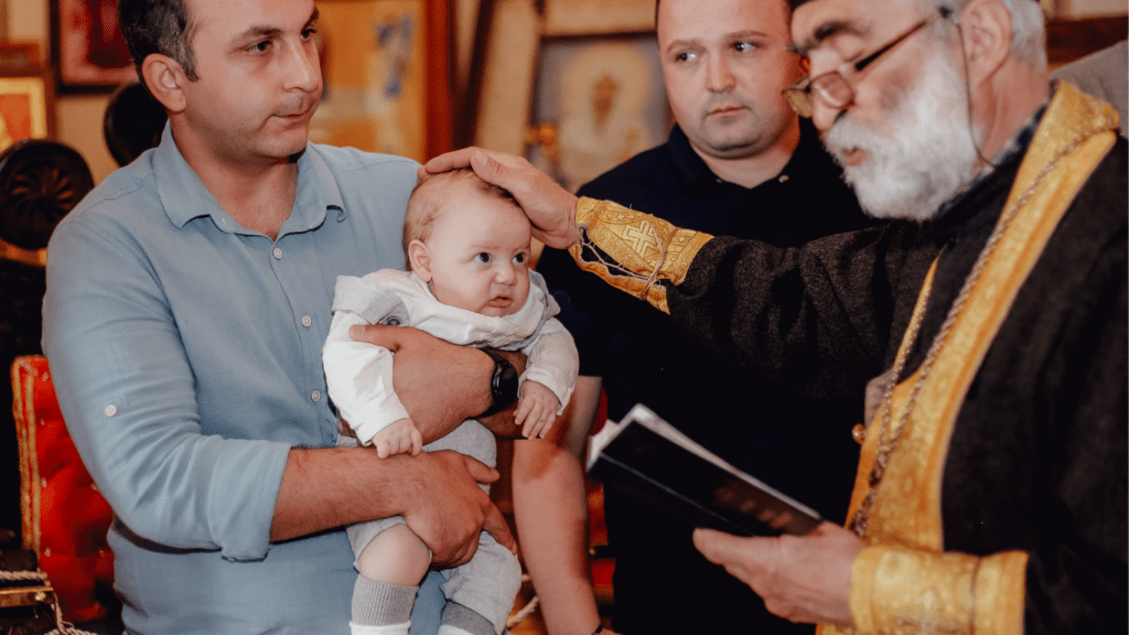 a person holding a baby while standing