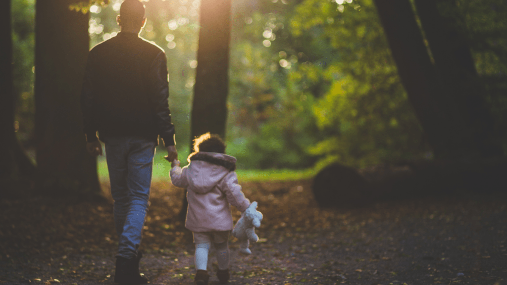 a person holding a child in the middle of a field