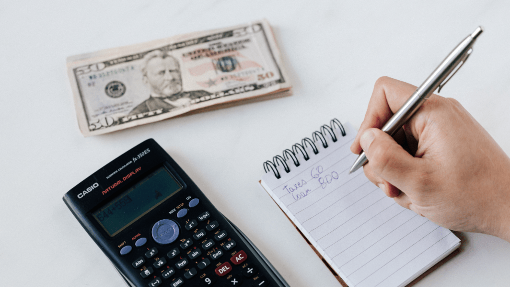 a person is using a calculator while sitting at a desk