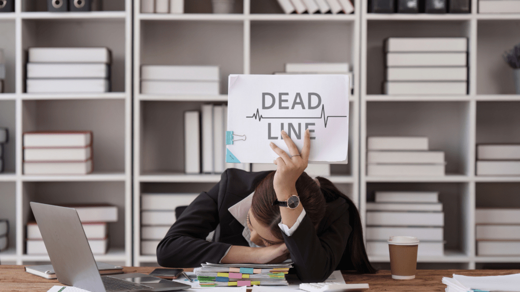 a person sitting at a desk with their head in their hands