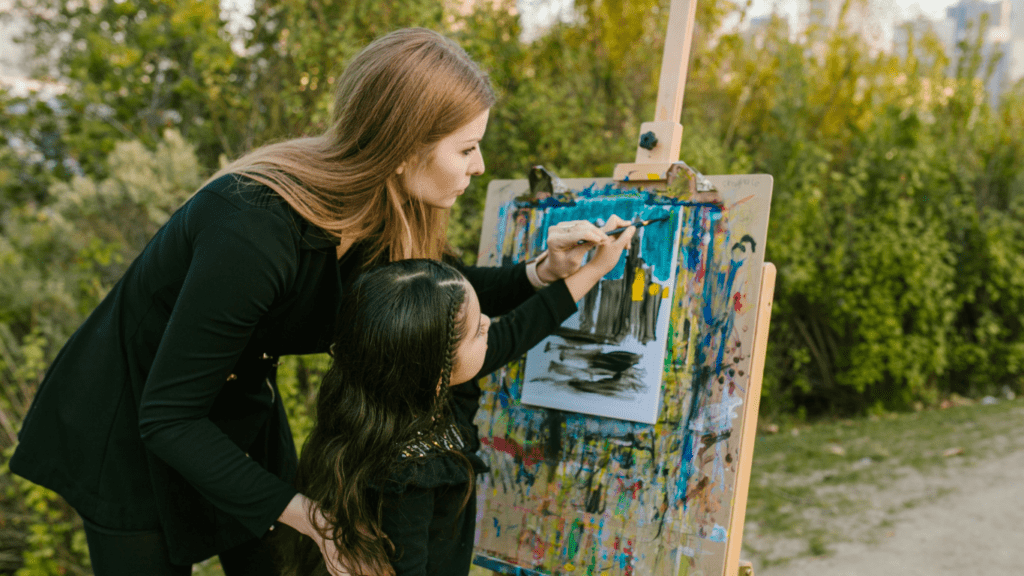 a woman and a child doing a painting