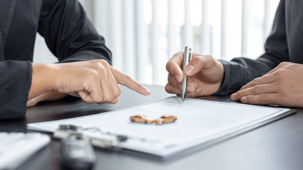 two business people sitting at a table with a pen and paper